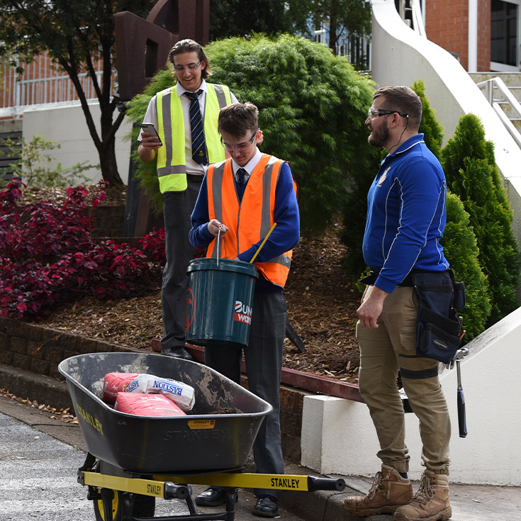 Patrician Brothers Catholic College Blacktown students in hi-vis vests working in the school gardens