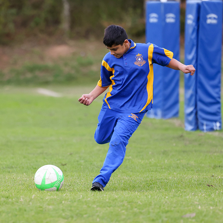 Patrician Brothers Catholic College Blacktown student kicking soccer ball